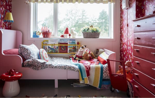 Chambre d’enfant décorée en rouge avec des motifs.