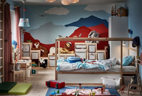 Chambre d’enfant ; sur le mur du fond, on a peint des montagnes. La chambre contient un lit réversible, un espalier, des jouets et divers systèmes de rangement.