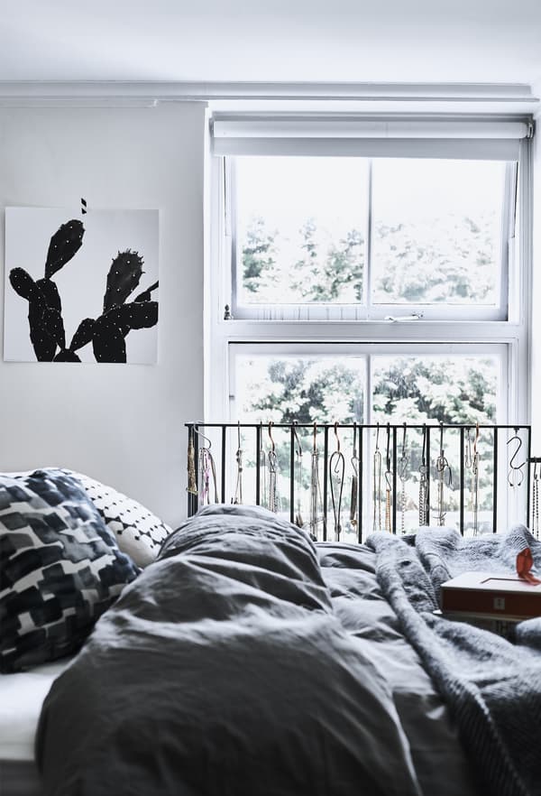 Chambre monochrome avec literie grise.