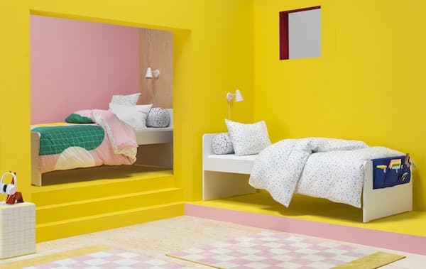 Chambre rose et jaune vifs, deux lits une place, housses de couette colorées à motifs graphiques 