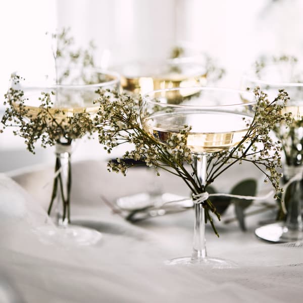 Champangeglas pyntade med blomkvistar.