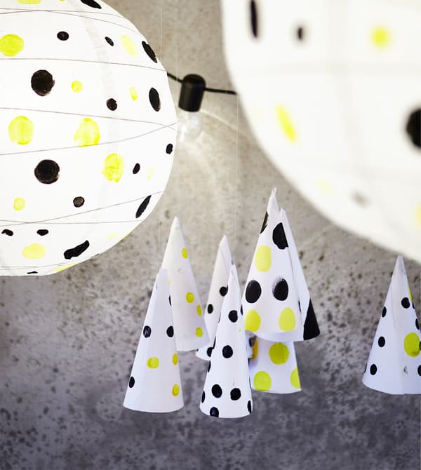 Chapeaux et abat-jour de lampes décorés de pois noirs et jaunes.