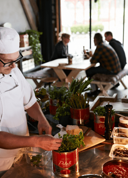 Chef in front of chopping board and ingredients picking some herbs