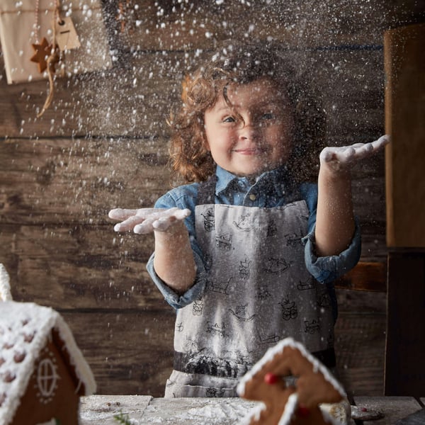 Child in kitchen making a gingerbread house