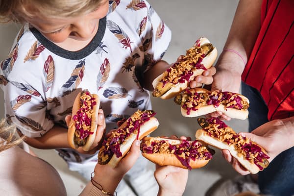 children grab their hotdog which is popular snack at Swedish Bistro