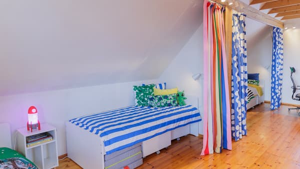 Children sleeping area with beds separated by colorful curtains