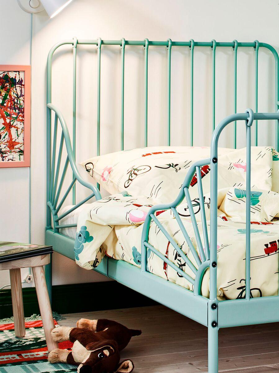 Children’s bed
Children’s bed with a green metal frame and playful printed bedding featuring animals and vehicles.