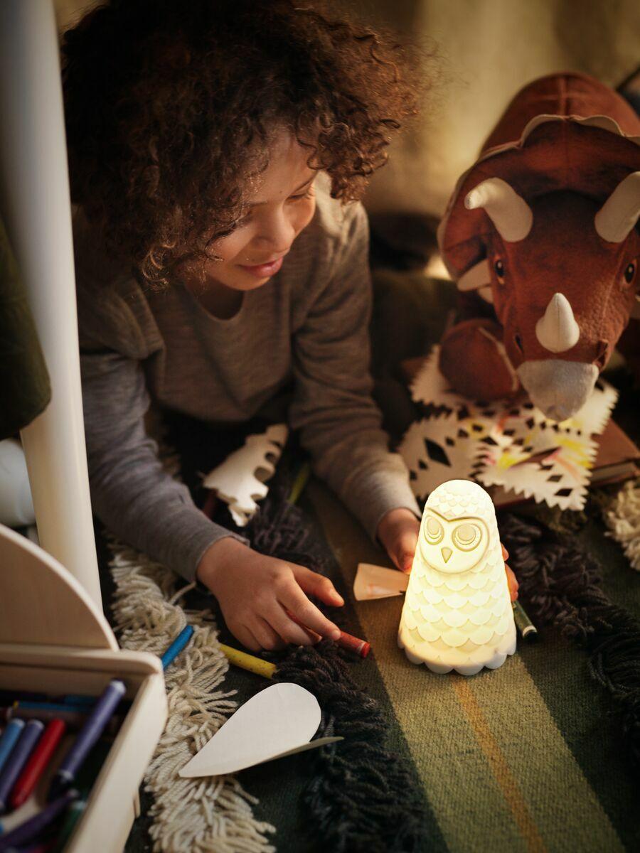 Children’s lighting
Child holding a soft, glowing night light shaped like a character, creating a warm, cozy atmosphere.