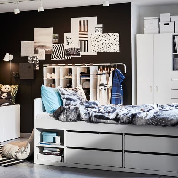 Children's room in white, blue and black with a white bed frame, tiger-patterned quilt cover and pillowcase and blue details.