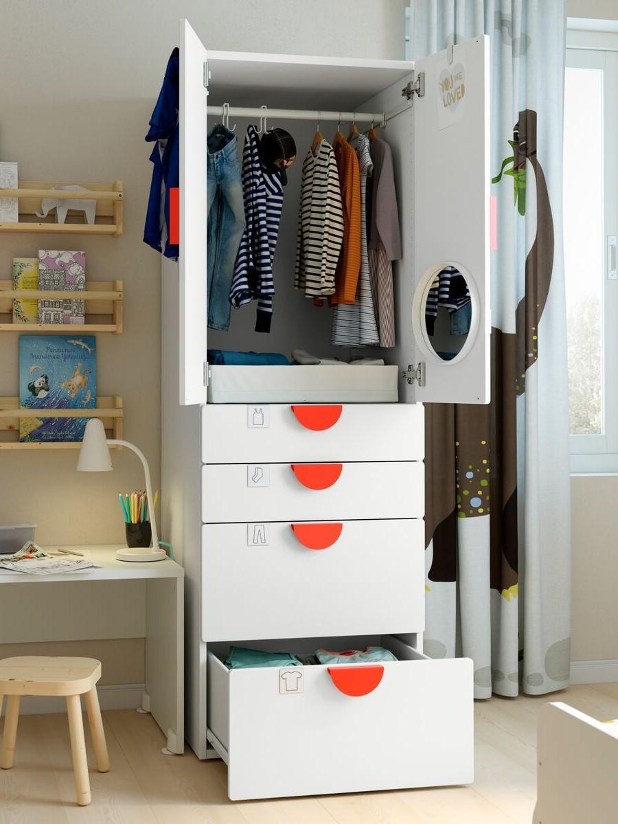 Children's wardrobe
Tall white wardrobe with open doors, displaying neatly hung children’s clothes and red-accented drawers.