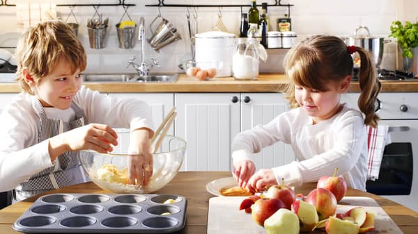 Chlapec a děvčátko v kuchyni připravují muffiny.