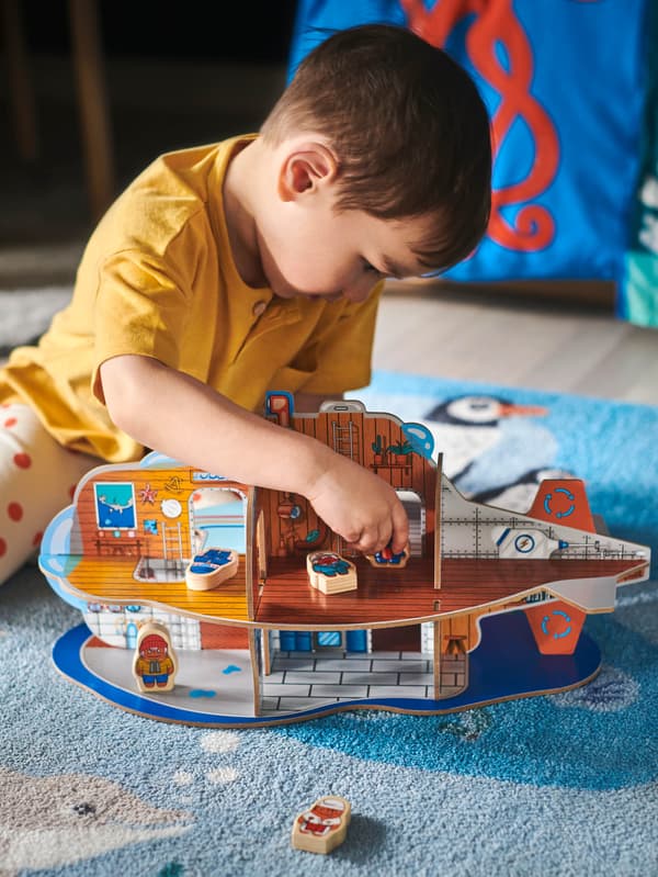 Chlapec sa hrá na koberci BLÅVINGAD s ponorkou BLÅVINGAD.