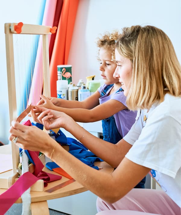 Chloé e sua figlia tessono uno scampolo su un telaio in legno - IKEA
