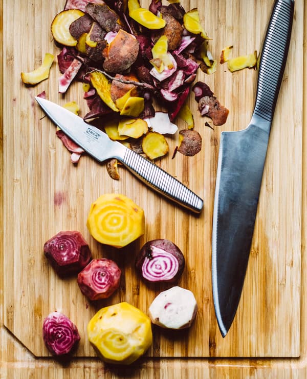 Chopping up yellow and red beets on a chopping board.