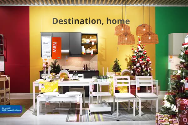Christmas-themed display at IKEA Pasay City, featuring festive decorations, dining settings, and decorated trees in vibrant colors.