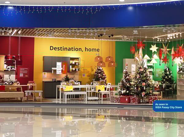 Christmas-themed display at IKEA Pasay City, featuring festive decorations, dining setting, and decorated trees in vibrant colors.