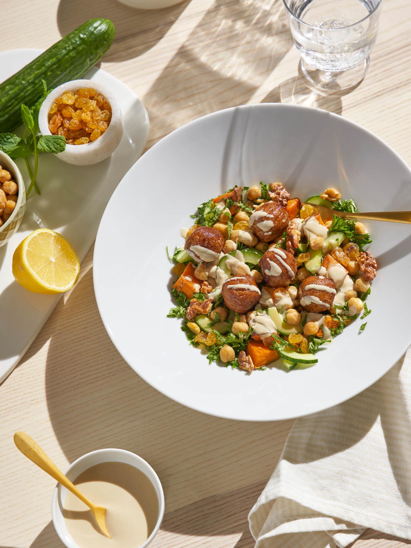 Cícerový šalát s bezmäsitými guľôčkami HUVUDROLL na bielom tanieri.