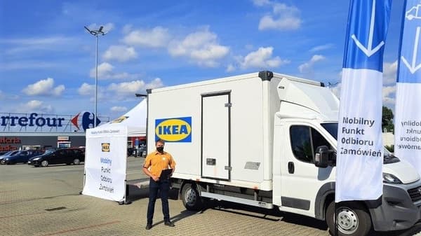 Ciężarówka i namiot z logiem IKEA oraz napisem "Mobilny Punkt Odbioru Zamówień" ustawione przed sklepem Carrefour.
