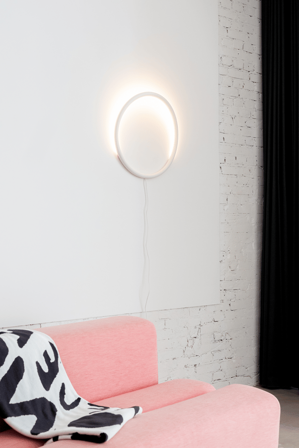 Circular LED light hangs on wall 