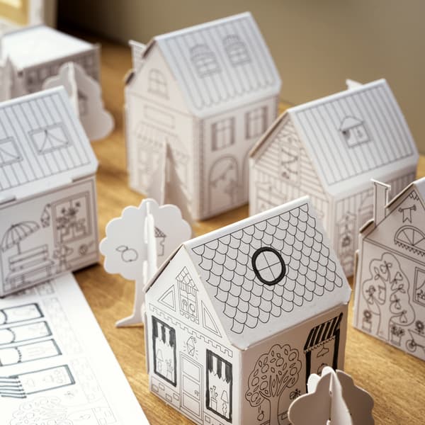 Città di cartone MÅLA con case e alberi, su una superficie in legno.