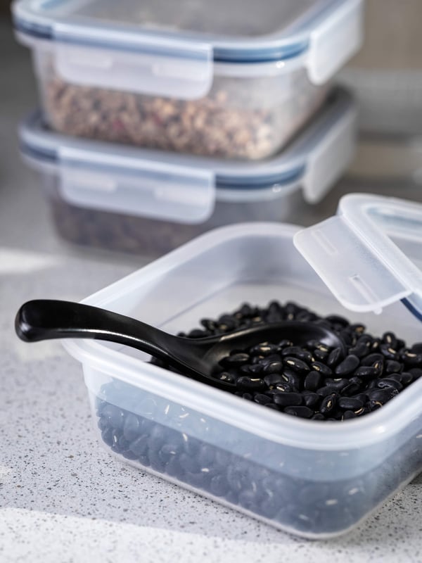 Clear food containers with food ingredients inside, including black beans.