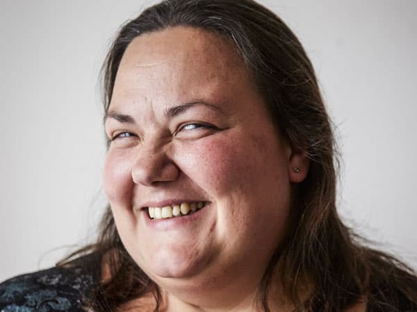 Close-up image of a smiling, dark haired woman.