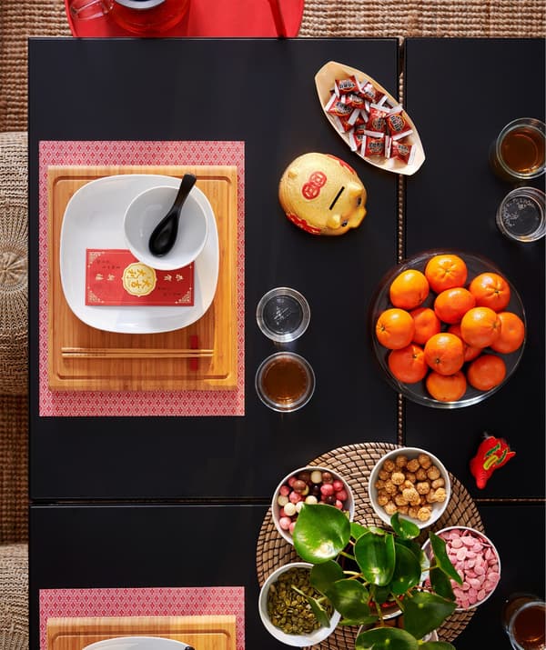 Close-up image of a table place setting with a red GALLRA place mat and food dishes.