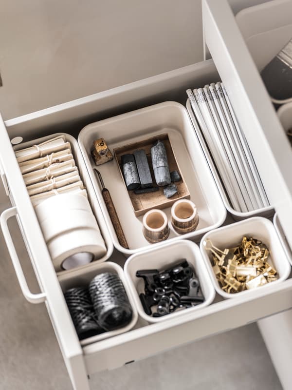Close up image of the inside of a desk drawer with organised accessories within