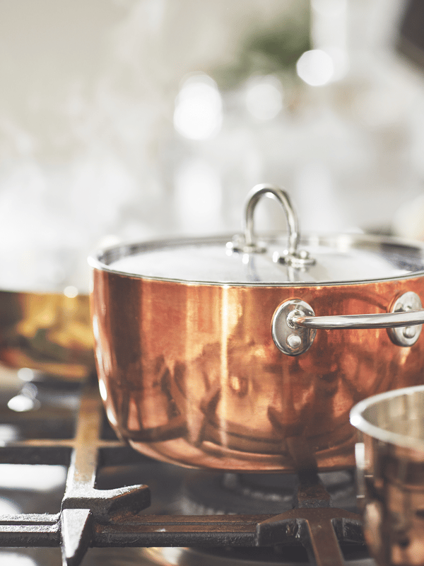 Close up of a copper saucepan on a gas hob
