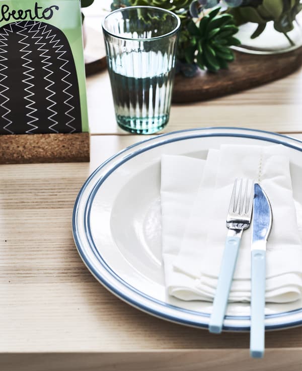 Close-up of a table setting including plate, napkin, knife and fork.
