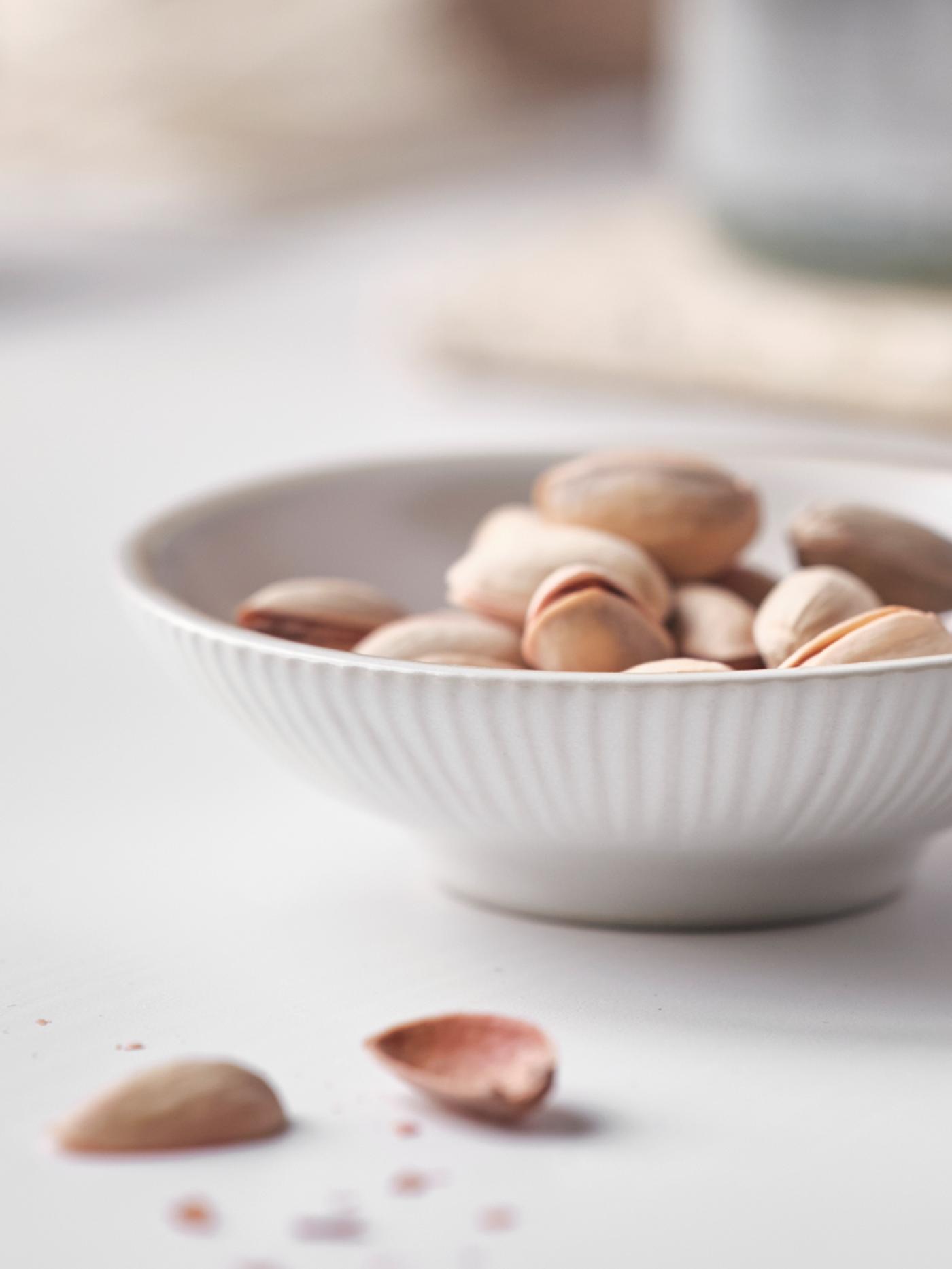 Close-up of a VÅRDANDE decorative ceramic bowl filled with an assortment of nuts.