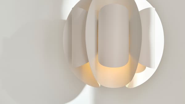 Close up of a white TRUBBNATE pendant lampshade, with a modern folded design and a diffused light.