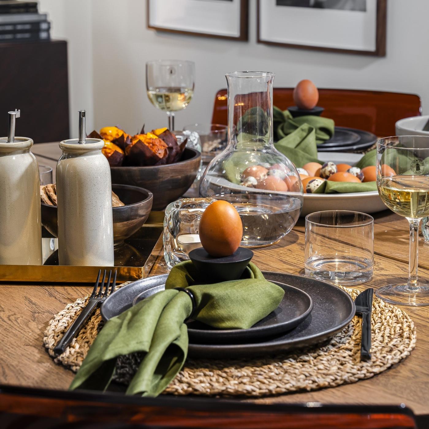 Close-up of an Easter table setting with earthy plates and soft green linen napkins.