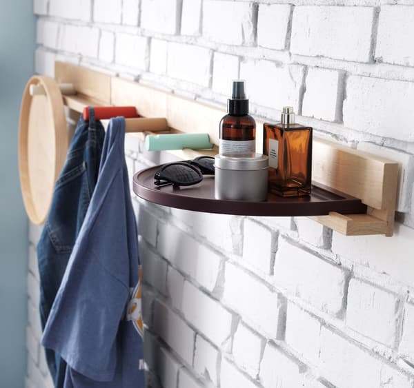 Close-up of an IKEA ledge with clothes hooks and a semi-circular shelf.