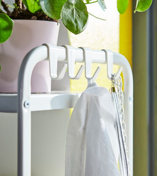 Close-up of an open shelving unit with smart hooks on the side.