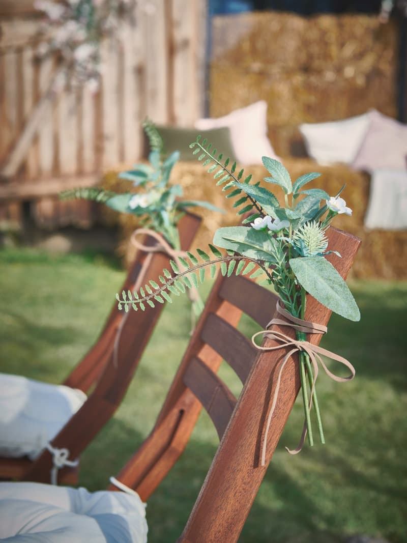 Close up of SMYCKA artifical bouquet tied to the back of a rustic wedding chair