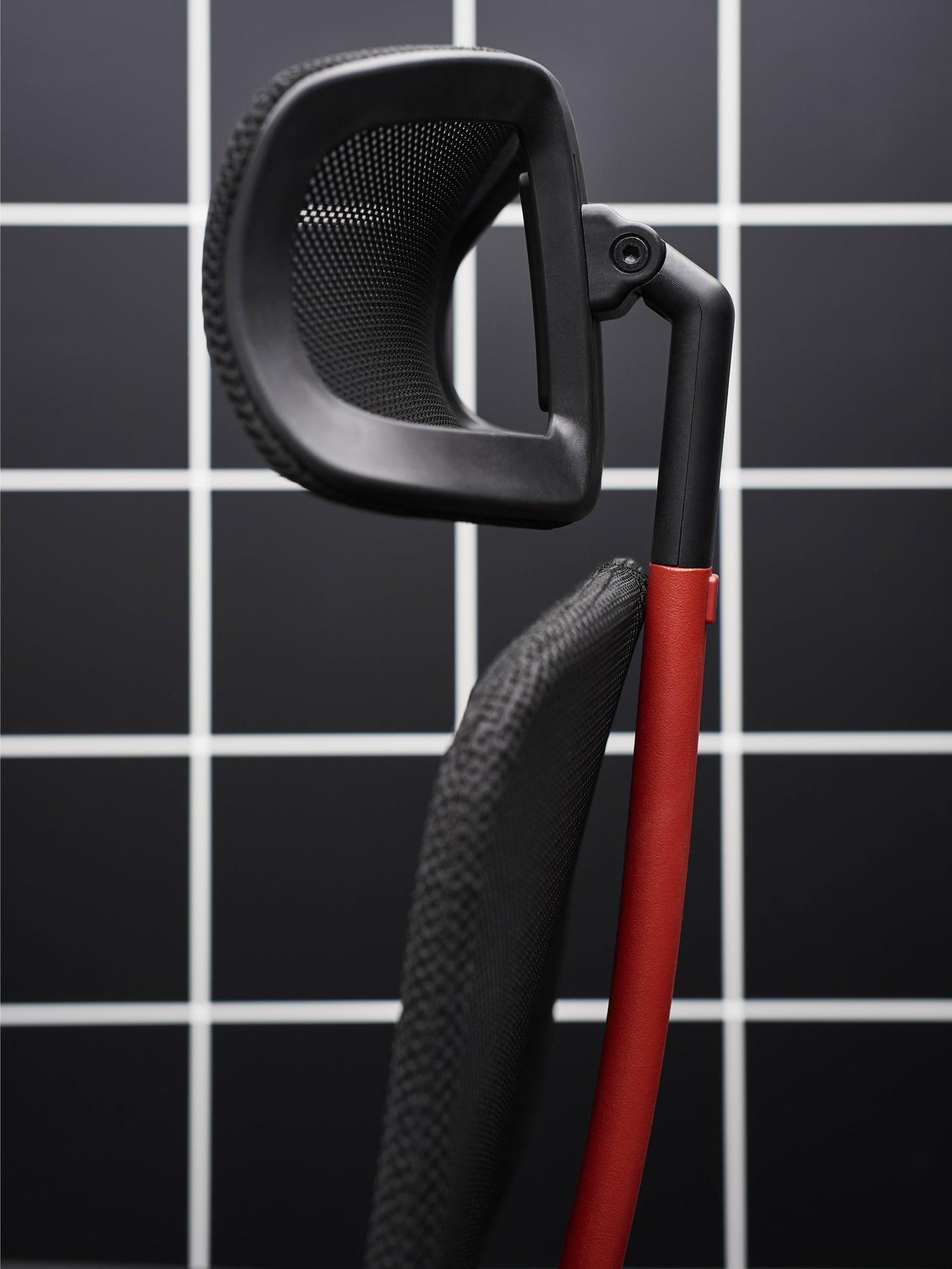 Close-up of the black headrest and the black and red back on a MATCHSPEL gaming chair against a black and white background.