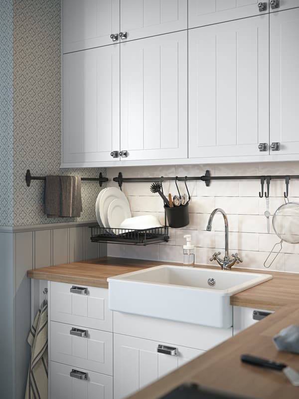 Close up of the corner of a traditional-style white STENSUND kitchen with wooden worktop and a white Belfast sink