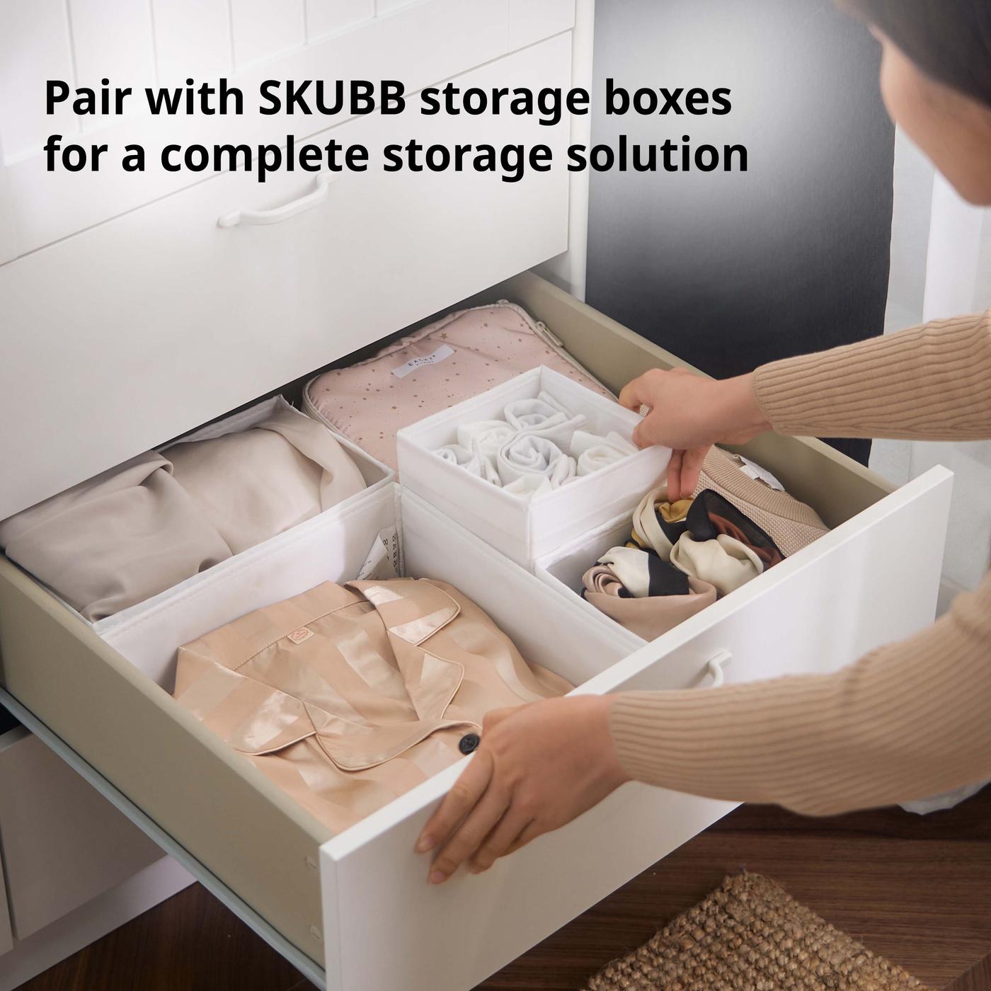 Close-up of white SKUBB storage boxes/organisers inside MUSKEN wardrobe drawers.