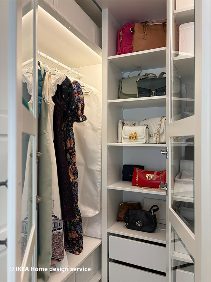 Close-up shot of dresses and handbags displayed in a floor-to-ceiling PAX wardrobe from a traditional modern 4-room BTO flat in MacPherson, Singapore, designed by IKEA Home design service.