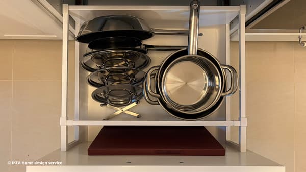 Close-up shot of stainless steel pots and pans in IKEA METOD kitchen drawer.