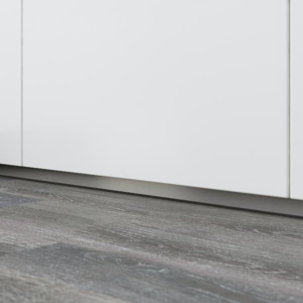 Closed dishwasher with detail of a baseboard