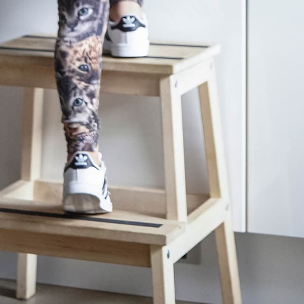 Closeup of a child climbing a BEKVAM step stool with anti-slip tape on the steps.