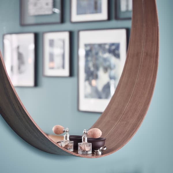 Closeup of STOCKHOLM mirror's deep ledge, holding a small perfume bottle.