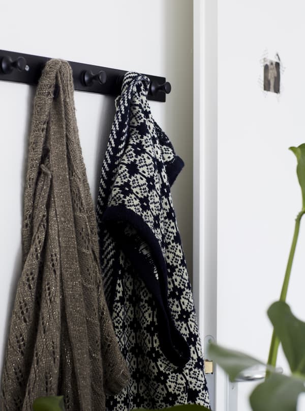 Clothes hanging on a row of hooks.
