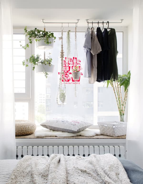 Clothes hanging on rails in a window alcove.