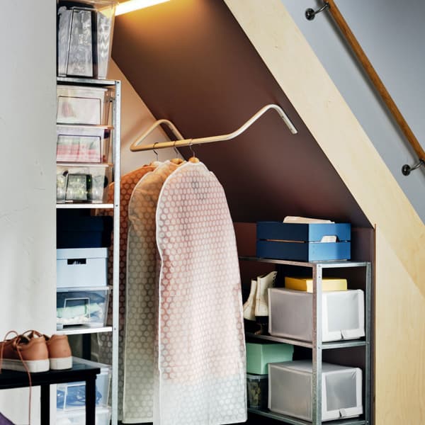 Clothes rack under staircase with well-organised shelving units, and boxes in different colours