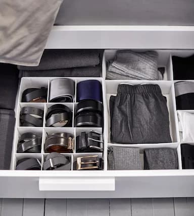 Clothing and belts are kept tidy with interior organisers inside a drawer uner the bed.