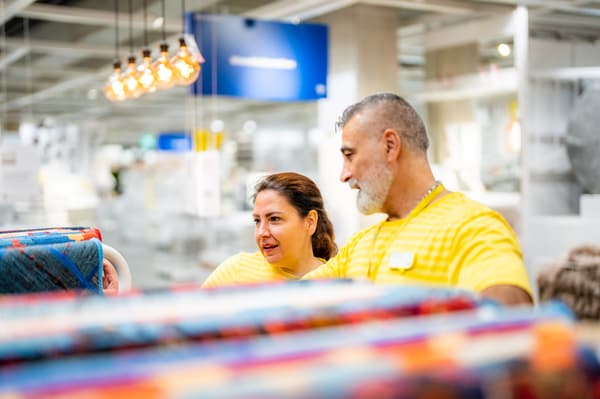 Co-worker IKEA che aiuta un cliente a progettare la propria cucina con il configuratore per la cucina.
