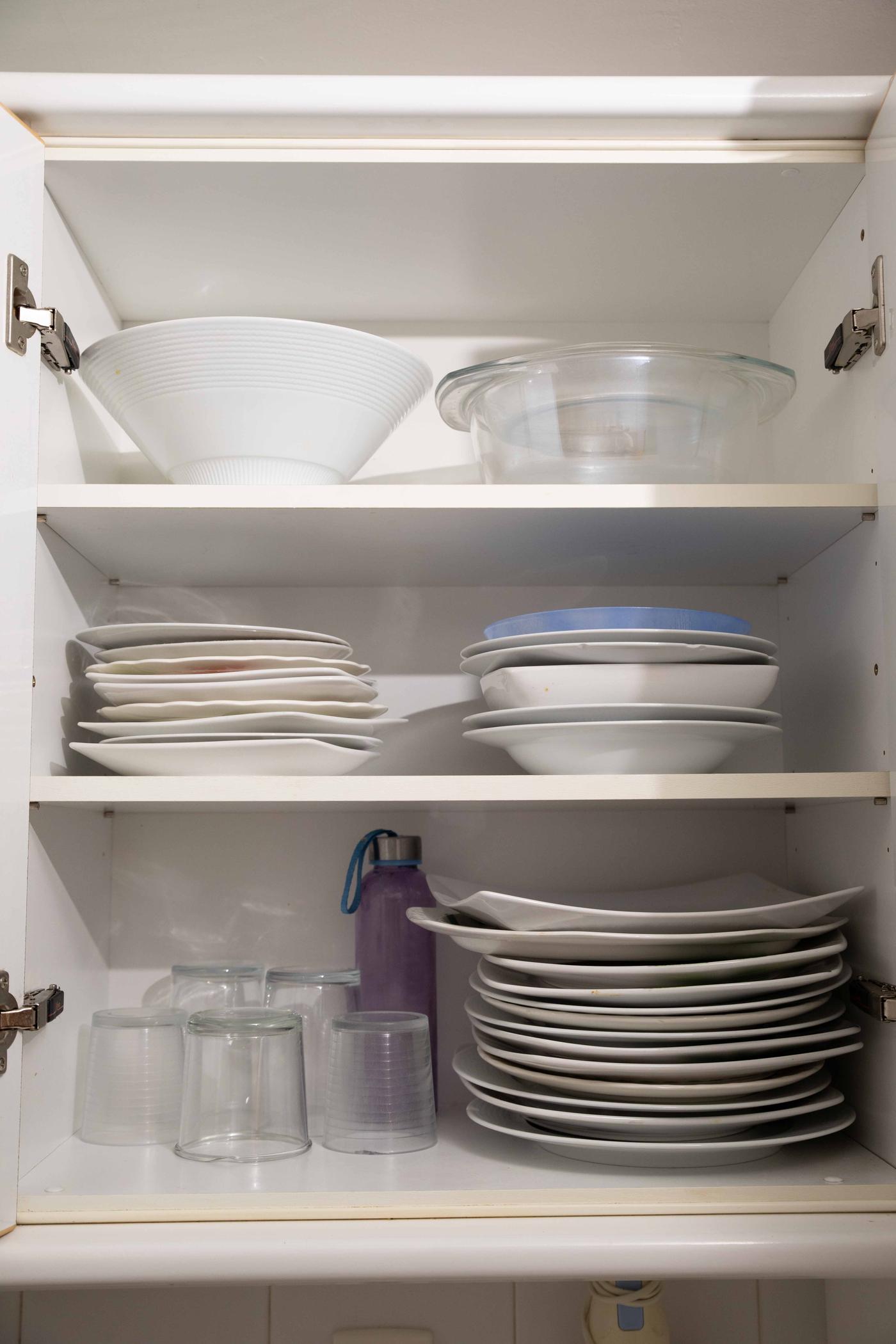 Cocina antes de ser reformada con estanterías, horno y utensilios de cocina.